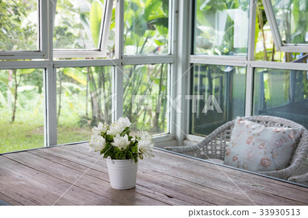 bouquet of white siam tulip flower in vase on wood table near window with garden view. decoration and interior 33930513