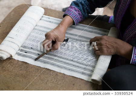 Hill tribe working on pattern of traditional clothes show for tourist Hill tribe working on pattern of traditional clothes show for tourist 33930524