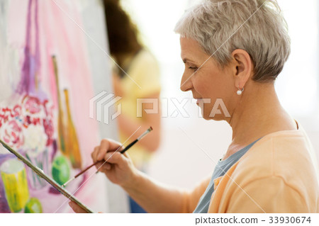 senior woman artist painting at art school 33930674
