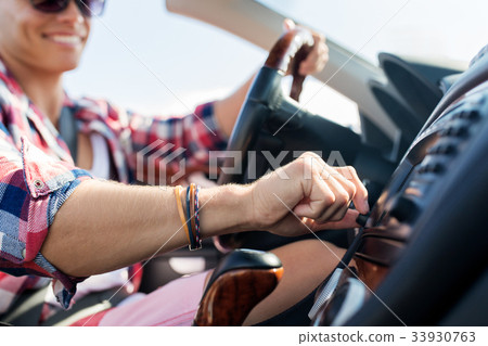 happy young man driving convertible car 33930763