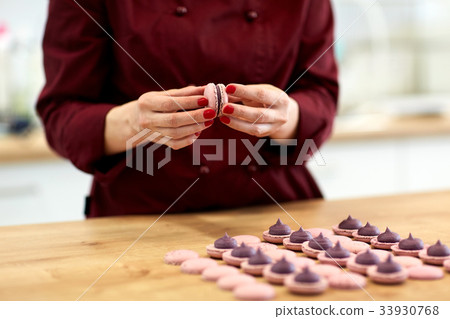 chef sandwiching macarons shells with cream chef sandwiching macarons shells with cream 33930768