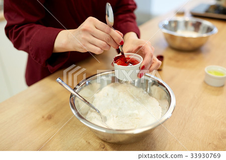 chef hands adding food color into bowl with flour chef hands adding food color into bowl with flour 33930769
