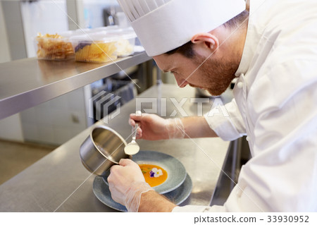 happy male chef cooking food at restaurant kitchen happy male chef cooking food at restaurant kitchen 33930952