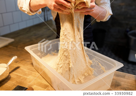 chef or baker cooking dough at bakery 33930982