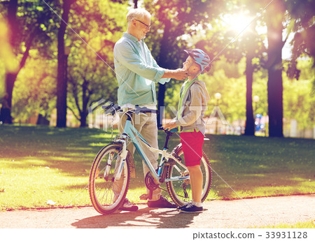grandfather and boy with bicycle at summer park grandfather and boy with bicycle at summer park 33931128