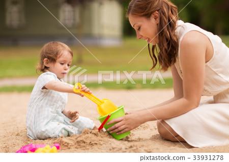happy mother with baby girl playing in sandbox happy mother with baby girl playing in sandbox 33931278
