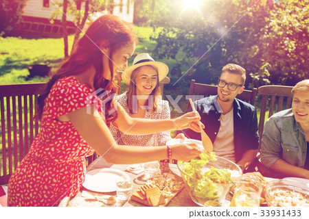 happy friends having dinner at summer garden party 33931433