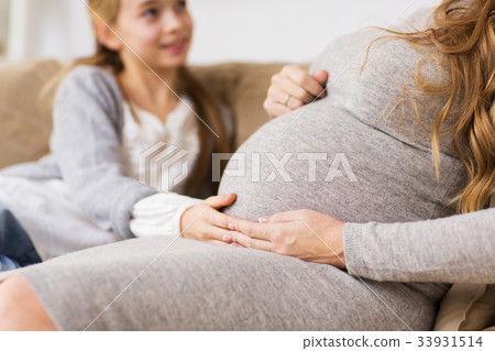 close up of pregnant woman and girl at home close up of pregnant woman and girl at home 33931514