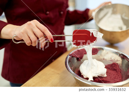 chef making macaron batter at kitchen 33931632