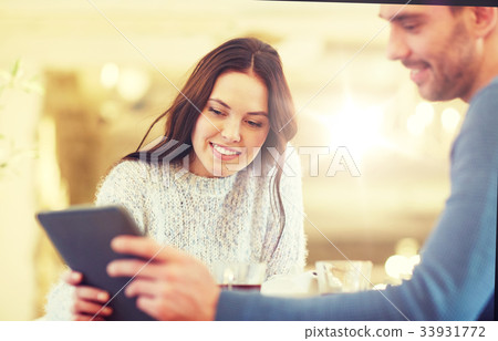happy couple with tablet pc drinking tea at cafe 33931772