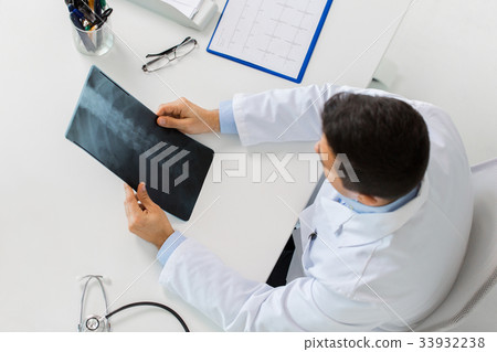 doctor with spine x-ray sitting at table 33932238
