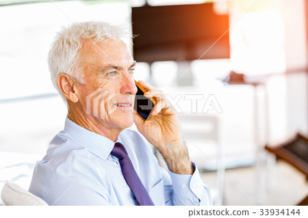 Businessman at the office with mobile phone Businessman at the office with mobile phone 33934144