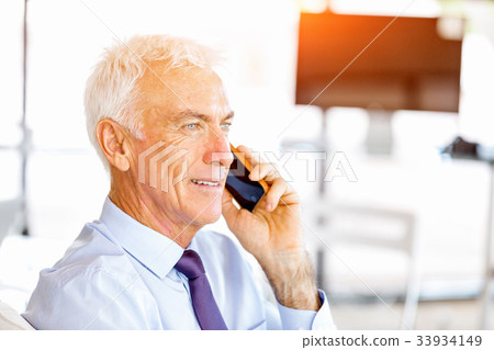Businessman at the office with mobile phone Businessman at the office with mobile phone 33934149
