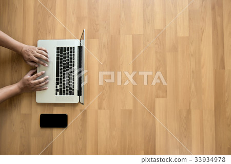 Top view man used of laptop hands on a wooden Top view man used of laptop hands on a wooden 33934978