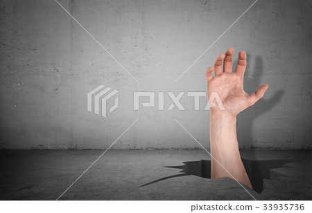 A large male hand forcing its way through a hole 33935736
