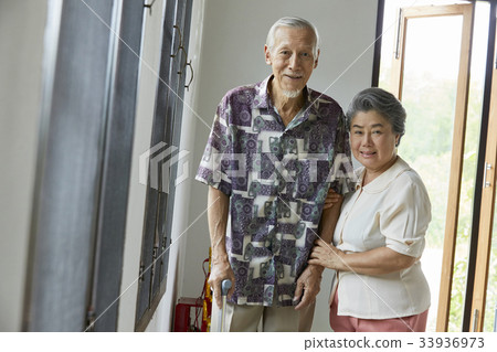 a senior couple is standing and smiling indoor 33936973