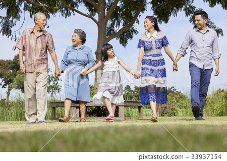 an extended family is walking outdoors and smiling happily an extended family is walking outdoors and smiling happily 33937154