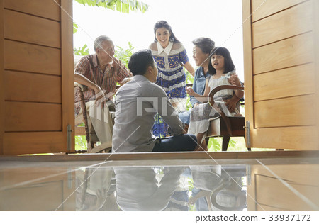 an extended family is talking together and smiling happily an extended family is talking together and smiling happily 33937172