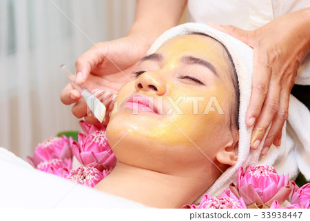 Happy relax woman getting gold facial mask Happy relax woman getting gold facial mask 33938447