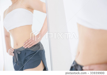 Woman looking at body through mirror Woman looking at body through mirror 33939900