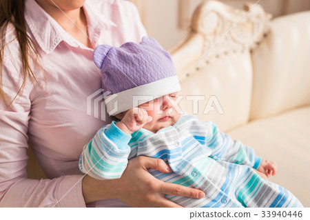 Close up of mother holding newborn baby in arms Close up of mother holding newborn baby in arms 33940446
