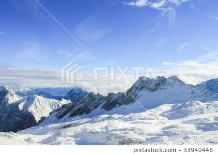 View of a mountain range with snow and clouds View of a mountain range with snow and clouds 33940448