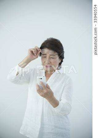 Senior woman presbyopia watch smartphone 33940554