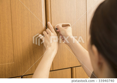 Woman closing key of locker of spa facility Woman closing key of locker of spa facility 33940740