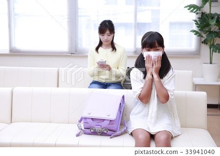 小學生和婦女戴著面具在候診室等待體檢 33941040
