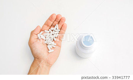 man take a pill on a white background. man take a pill on a white background. 33941777
