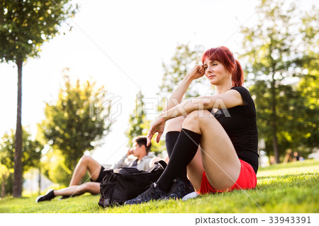 Beautiful runner in the city resting in park. Beautiful runner in the city resting in park. 33943391