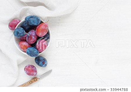 Wooden background with plums and white towel Wooden background with plums and white towel 33944788