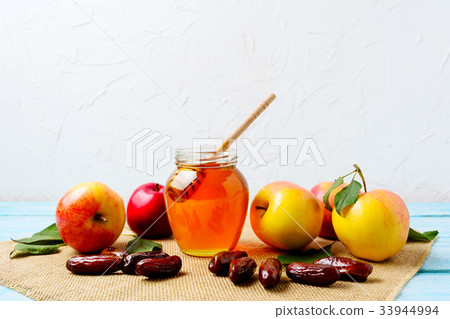 Honey jar, dates and ripe apples on burlap napkin Honey jar, dates and ripe apples on burlap napkin 33944994
