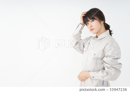 Woman in working clothes working in a factory 33947236