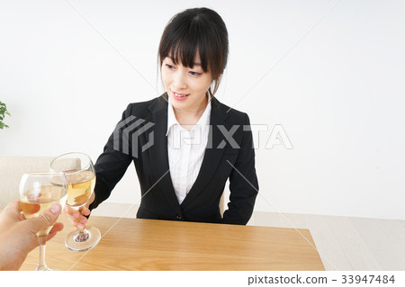 Young woman drinking alcohol in a suit 33947484
