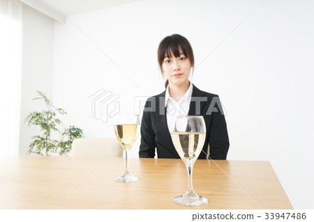 Young woman drinking alcohol in a suit 33947486