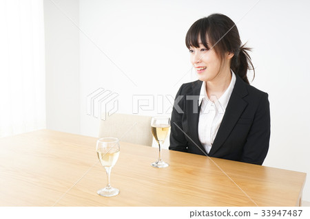 Young woman drinking alcohol in a suit 33947487