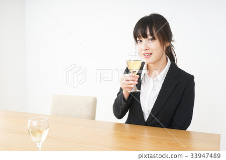 Young woman drinking alcohol in a suit 33947489