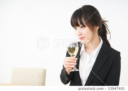 Young woman drinking alcohol in a suit Young woman drinking alcohol in a suit 33947491