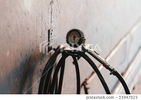 Hydraulic tire pressure meter in a workshop. Hydraulic tire pressure meter in a workshop. 33947815