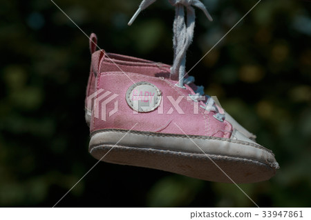 Old baby sneakers closeup photo. Old baby sneakers closeup photo. 33947861