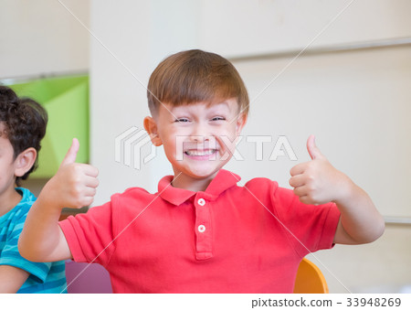 Kindergarten kid smile and thumbs up classoom 33948269