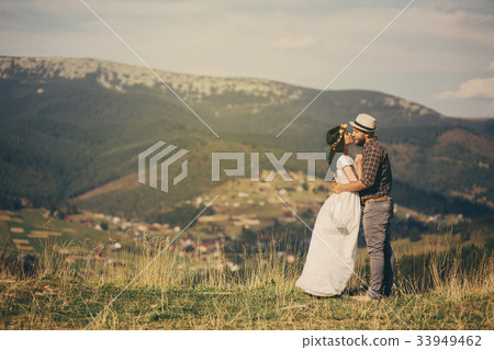 happy loving couple sitting on plaid in field happy loving couple sitting on plaid in field 33949462