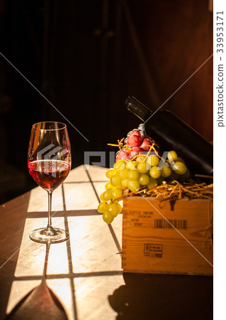 Wine glass placed next to the fruit box and wine 33953171