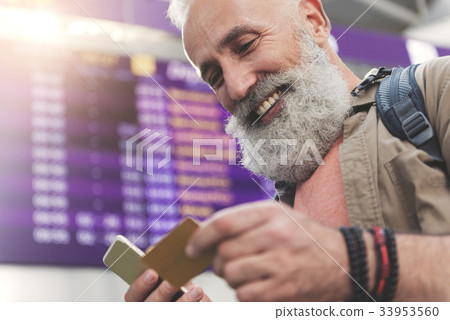 Cheerful grandfather typing on mobile 33953560