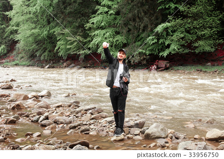 guy doing selfie on the background of rough river guy doing selfie on the background of rough river 33956750