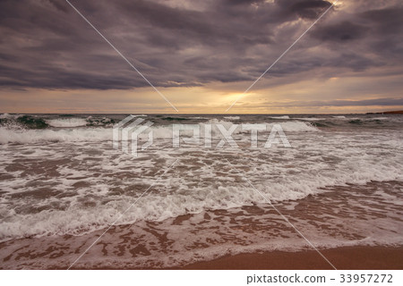 Majestic ocean sunrise with a breaking wave. 33957272