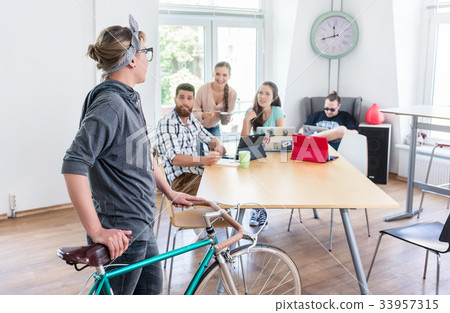 Active young woman holding a commuter bike in a 33957315