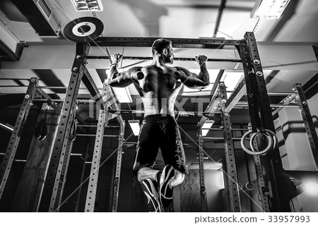 Shirtless man pulling up on horizontal bar. Shirtless man pulling up on horizontal bar. 33957993