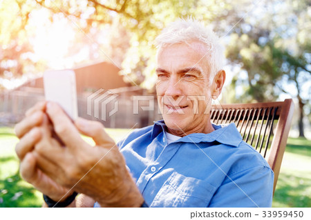 LoMature man outdoors using mobile phone 33959450